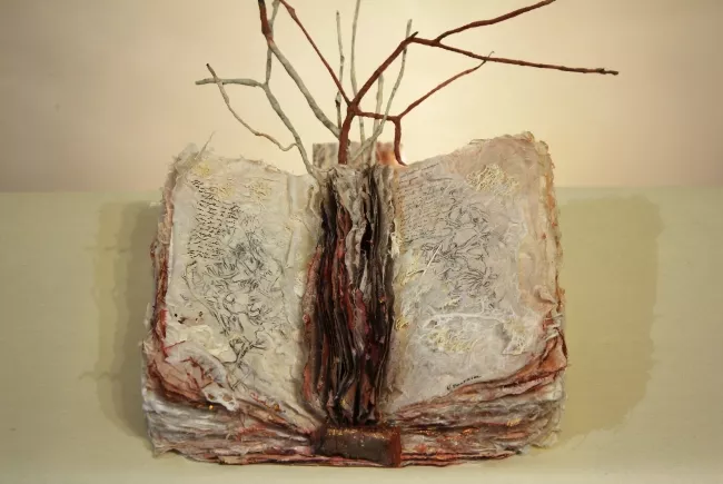 Sculpture en papier de Viviane Fontaine, intitulée ”Livre Arbre”, représentant un livre ouvert, duquel des racines en sortent