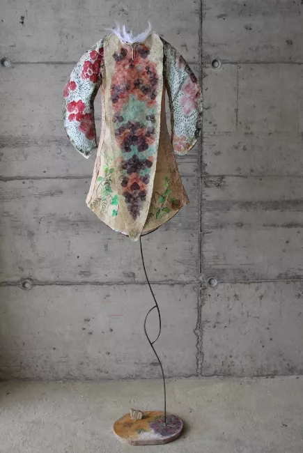 Sculpture en papier de Viviane Fontaine, intitulée ”Prince des fleurs”, représentant un vêtement orné de fleurs et tenu d'un pied en tige de métal