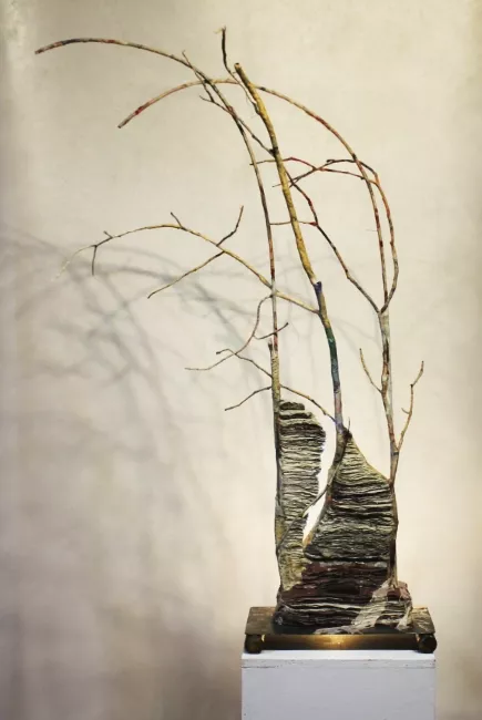 Sculpture en papier de Viviane Fontaine, intitulée ”Arbre aux souhaits”, représentant un amas de rochers desquels sortent des branches